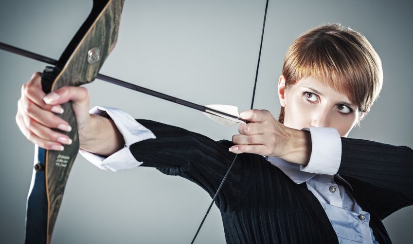 Business woman focused on target Business woman focused on target grey background